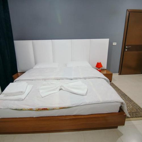 a bed with two white towels and a bow tie on it at Vila Panorama 2 Voskopojë in Voskopojë