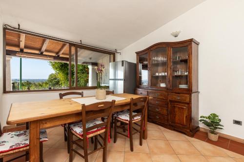 a kitchen with a wooden table and chairs and a refrigerator at Casa Isolotto D'Ogliastra - vista mare in Lotzorai