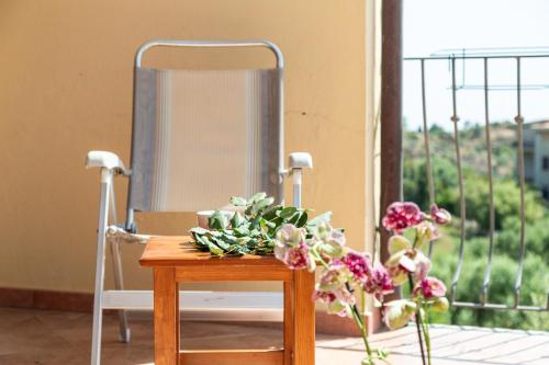 a table with flowers on it next to a window at Casa Isolotto D'Ogliastra - vista mare in Lotzorai