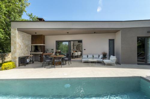 a house with a swimming pool next to a house at Villa Veros for 5 people near Labin - Rabac with private pool & kids playground in Labin