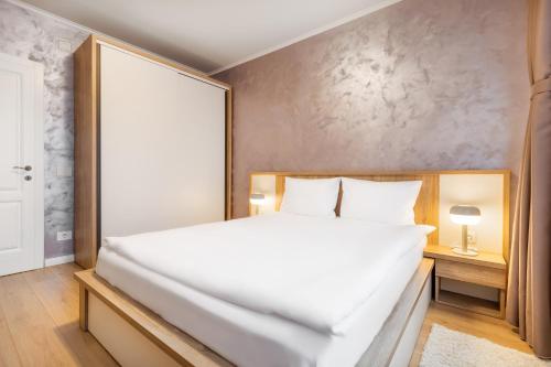 a bedroom with a large white bed and a wall at Quebec Flat in Oradea