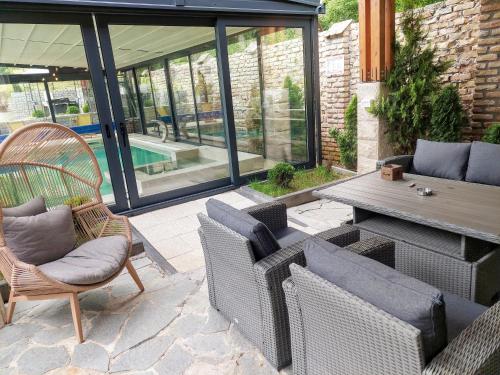 a patio with wicker chairs and a table and a pool at Vila MP Banstol 4*- Brdež do, Fruška gora in Inđija