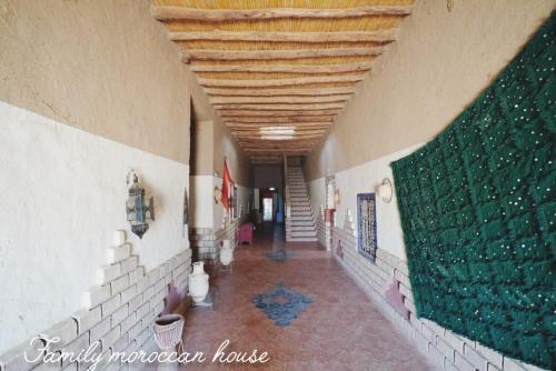 a hallway in a building with a green wall at Family Moroccan House in Merzouga