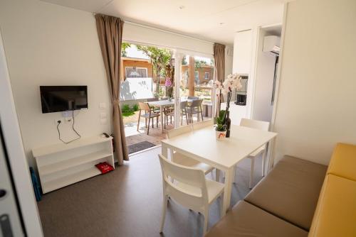 a living room with a table and a dining room at Camping Fossalta in Lazise