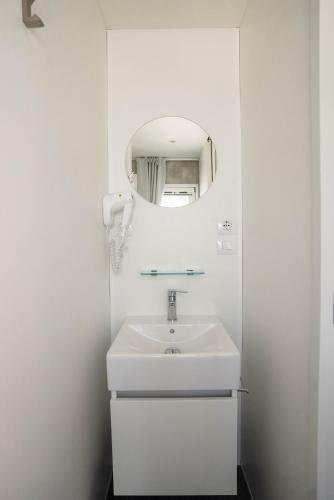 a white bathroom with a sink and a mirror at Camping Fossalta in Lazise