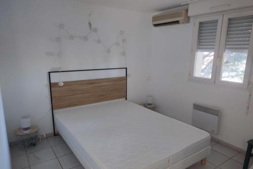 une chambre avec un lit dans une pièce blanche dans l'établissement Très beau T2 - Emeraude 40, à Canet