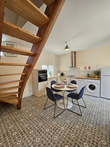 une cuisine avec une table et des chaises dans une pièce dans l'établissement Maison au calme, centre ville, à Périgueux