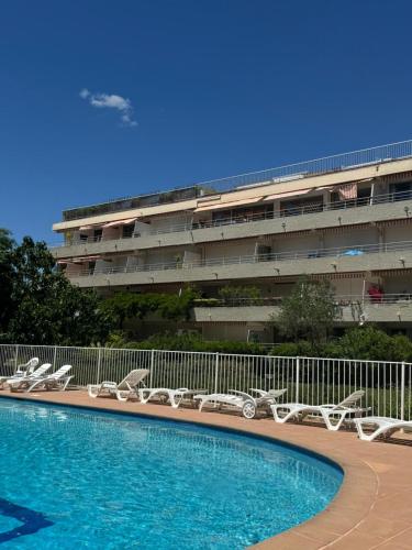 une piscine avec des chaises longues devant un immeuble dans l'établissement Studio in Saint tropez, swimming pool and parking, à Saint-Tropez