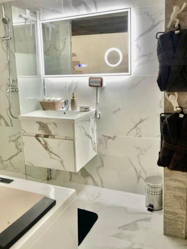 une salle de bain blanche avec un lavabo et un miroir dans l'établissement Nice Room, à Nice