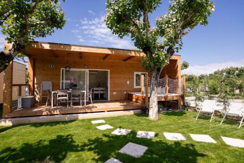 a small house with a deck and a yard at Camping Fossalta in Lazise