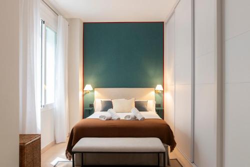 a bedroom with a bed with a green wall at Alohamundi Chicarreros Catedral in Seville