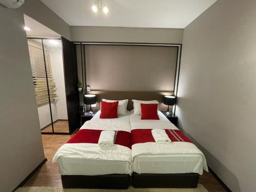a bedroom with a large bed with red pillows at Amazing Seaview Duplex George Town Maritime Suites 20 in George Town