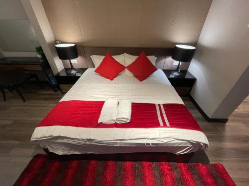 a bedroom with a large bed with red pillows at Amazing Seaview Duplex George Town Maritime Suites 20 in George Town