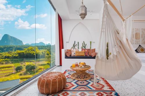 a room with a hammock and a large window at Yangshuo KIRA Hotel - Moroccan Style in Yangshuo