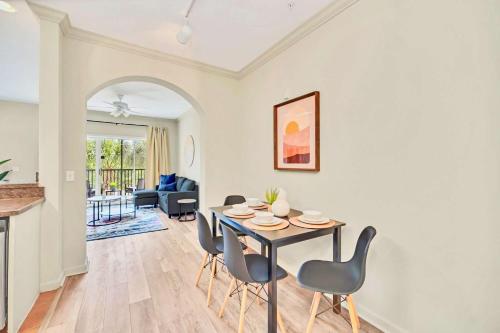 a dining room and living room with a table and chairs at Near Disney - 2BR Condo Unit - Pool and Hot Tub in Orlando