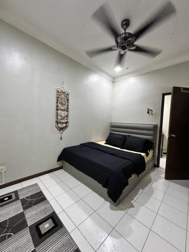a bedroom with a bed and a ceiling fan at DIAZ Homestay in Sungai Buluh