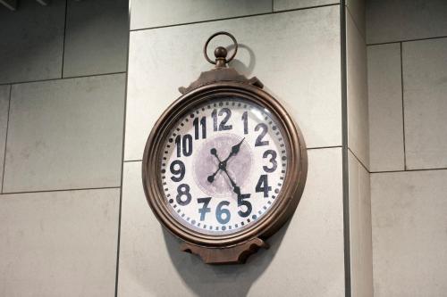 a clock hanging on the side of a wall at MK STAY - formerly HOTEL MK in Hong Kong
