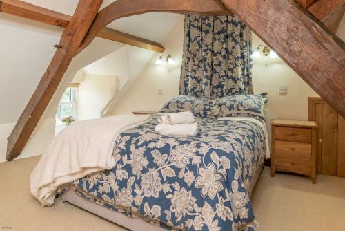 a bedroom with a bed with a blue and white bedspread at Bwthyn-Betws in Dolbenmaen