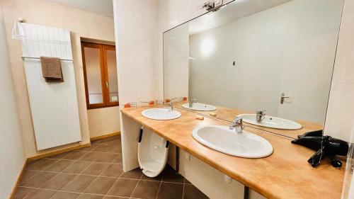 une salle de bain avec deux lavabos et un miroir dans l'établissement Maison à la campagne, à Castelsarrasin