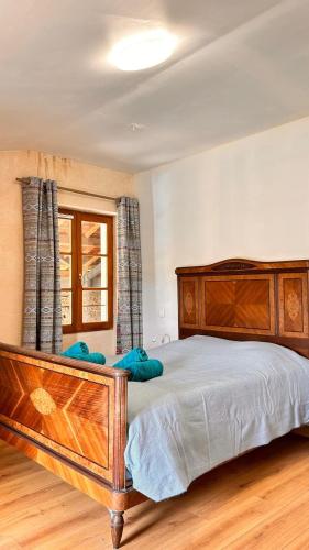 - une chambre avec un grand lit en bois et une fenêtre dans l'établissement Maison à la campagne, à Castelsarrasin