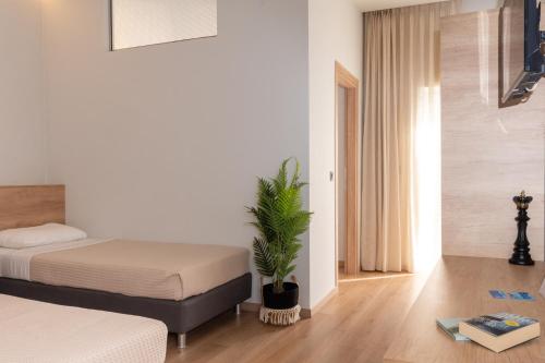 a bedroom with a bed and a potted plant at Bali Seaside Sailor in Balíon