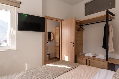 a bedroom with a bed and a flat screen tv at Bali Seaside Sailor in Balíon