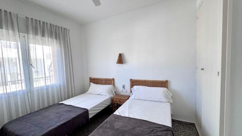 two beds in a room with a window at Las perlas VYBDenia in Denia