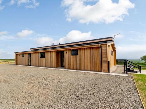 a large wooden building with a gravel driveway at 2 Bed in St Andrews 83173 in Anstruther