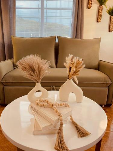 a coffee table with two vases and a couch at Your Home Away from Home in Buga
