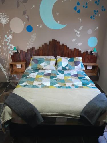 1 dormitorio con 1 cama con colcha colorida en Dreams, en Vryheid