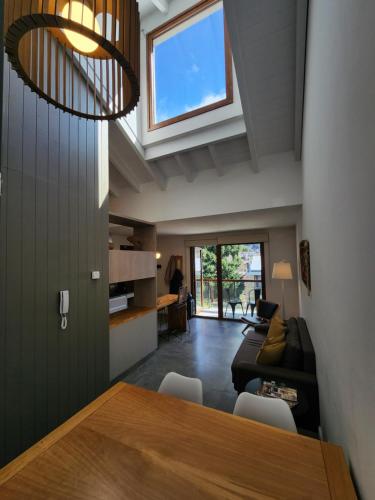 a kitchen and living room with a table and a couch at Álamos de los Andes - Andarlibre in San Martín de los Andes