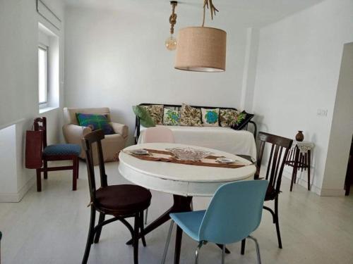 a living room with a table and chairs and a couch at Casa del Parque in Níjar
