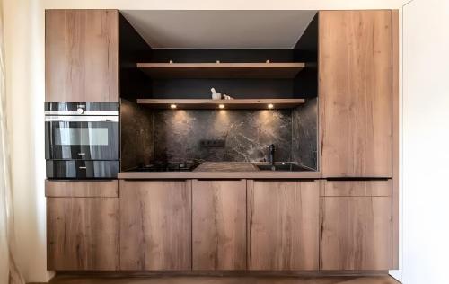 a kitchen with wooden cabinets and a sink at Boutique Hotel Santer Klause in Merano
