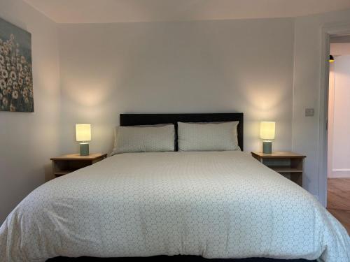 a bedroom with a large bed with two lamps at Cottage 486 - Roundstone in Roundstone