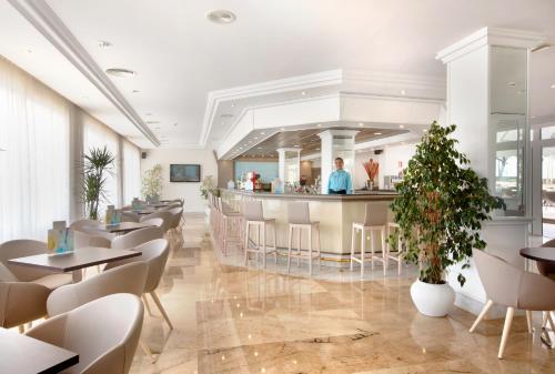 a restaurant with a bar and tables and chairs at Grupotel Orient in Playa de Palma