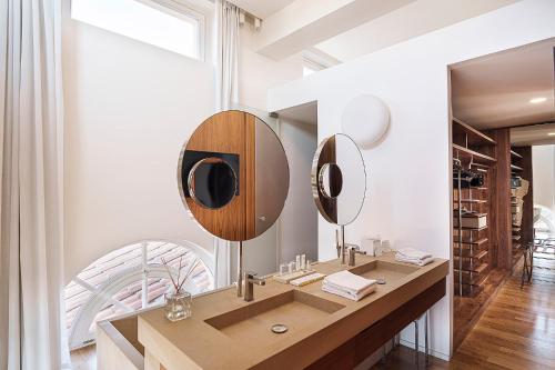 a bathroom with a wooden vanity with two mirrors at Palazzo Montemartini Rome, A Radisson Collection Hotel in Rome