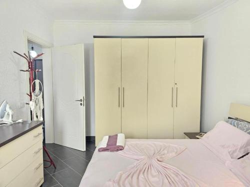 a bedroom with a large bed with white cabinets at Main Seaview Apartment Durres in Golem