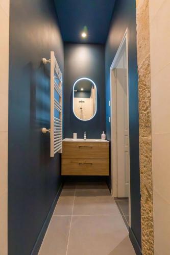 une salle de bain avec un lavabo et un miroir dans l'établissement L'Atre des Ducs, au centre historique de la ville, à Dijon