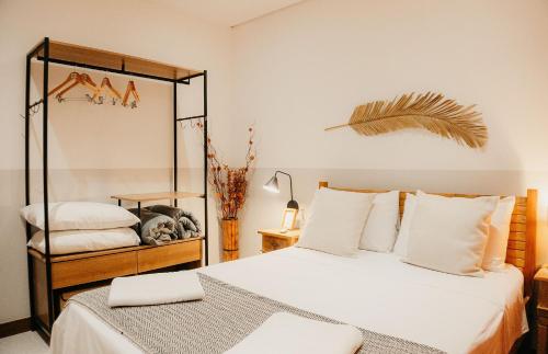 een slaapkamer met twee bedden en een spiegel bij Vila Trancoso Perequê in Ilhabela