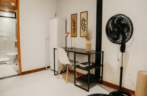 een kamer met een bureau met een stoel en een ventilator bij Vila Trancoso Perequê in Ilhabela