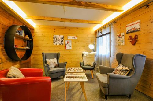 a waiting room with chairs and a table and a mirror at Chalet La Scie in Morgins