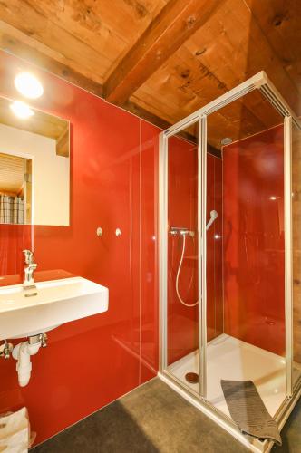 a bathroom with a glass shower and a sink at Chalet La Scie in Morgins