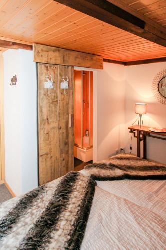 a bedroom with a bed and a wooden ceiling at Chalet La Scie in Morgins