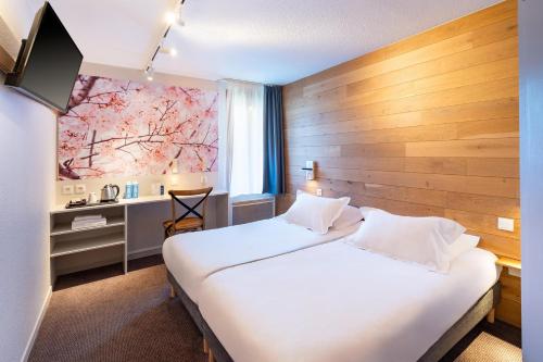 una camera d'albergo con due letti e una finestra di Sure Hotel by Best Western Rennes Chantepie a Chantepie