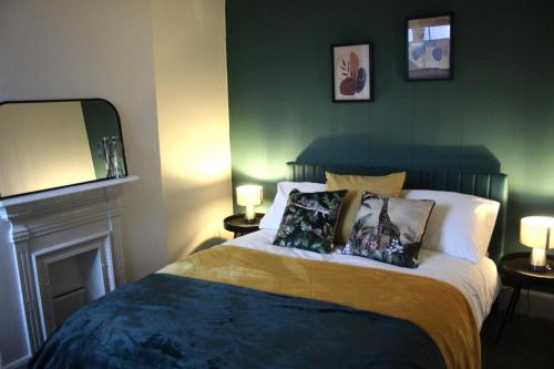 a bedroom with a bed with two pillows on it at The Velveteen Townhouse in Colchester