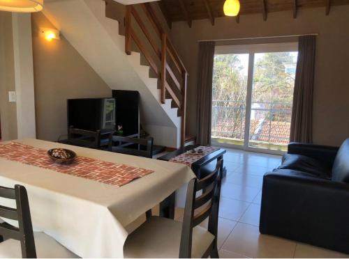 a living room with a dining room table and a television at Valeria Beach in Valeria del Mar