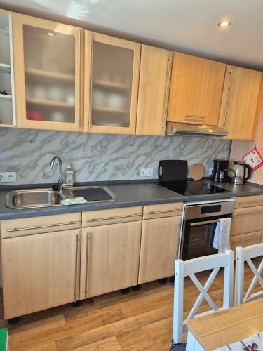 a kitchen with wooden cabinets and a sink at Picco 2 in Beuren