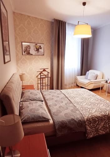 a bedroom with a bed and a chair in it at Lux-Apartment in Medieval Part of Old Riga in Riga