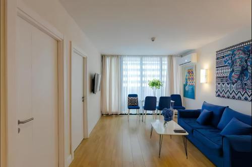 a living room with a blue couch and blue chairs at Batumi black sea view central Hotel in Batumi