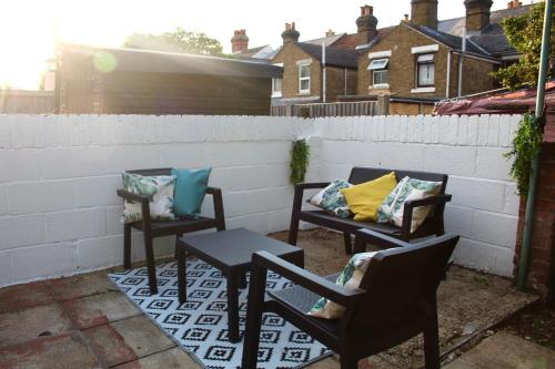 three chairs and a table on a patio at The Velveteen Townhouse in Colchester